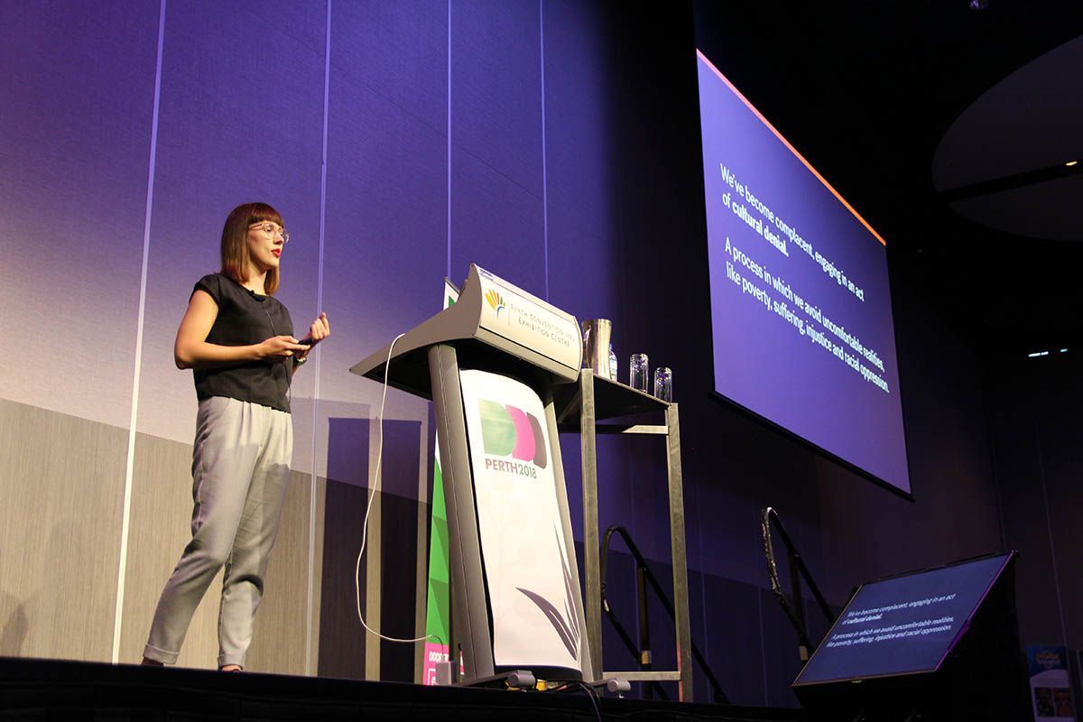 Karolina on stage at DDD Perth. She looks focused as is mildly gesturing.