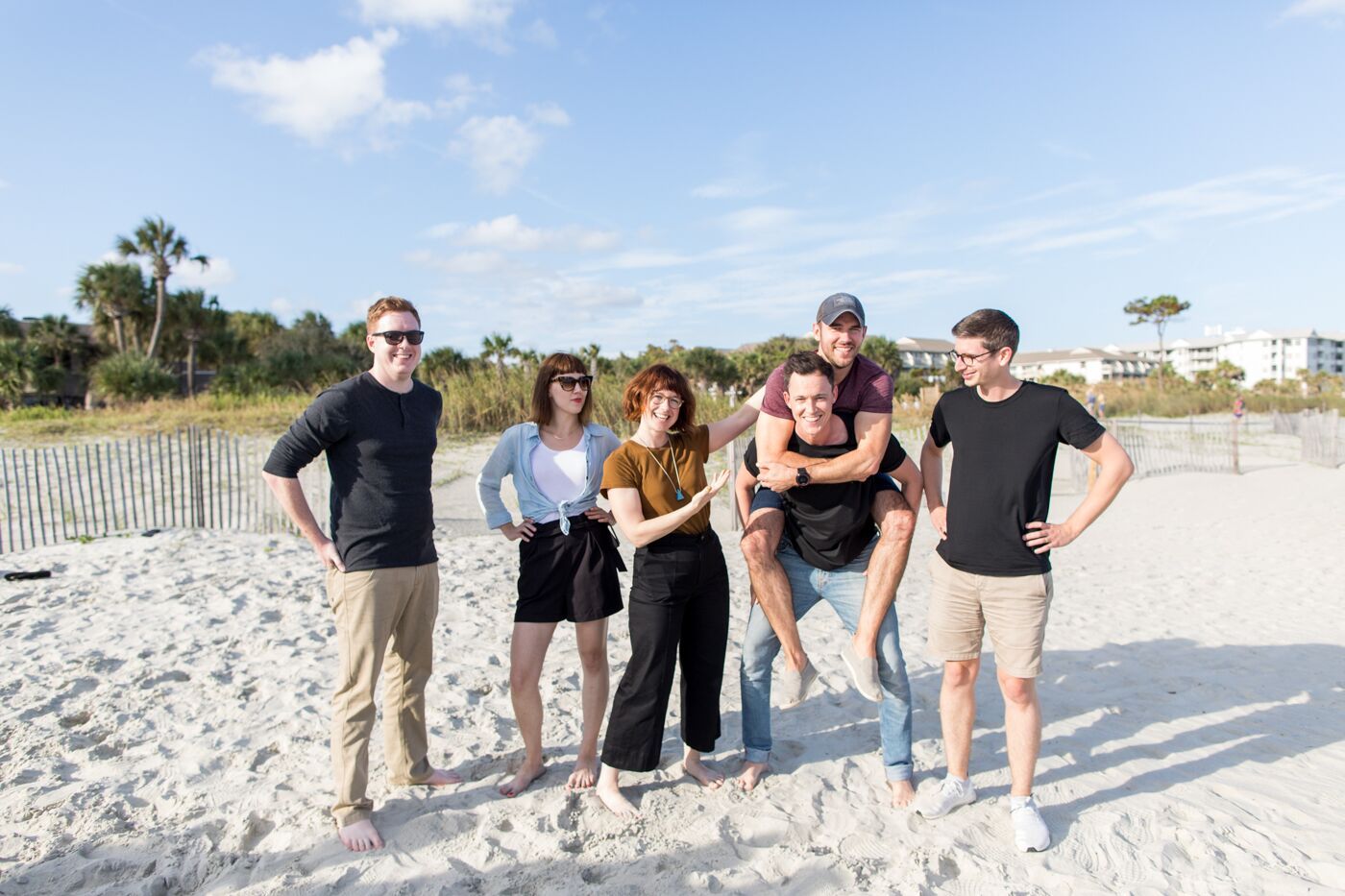 THelp Scout design team at the offsite in Hilton Head, SC, posing on the beach. There is one person piggybacking another.